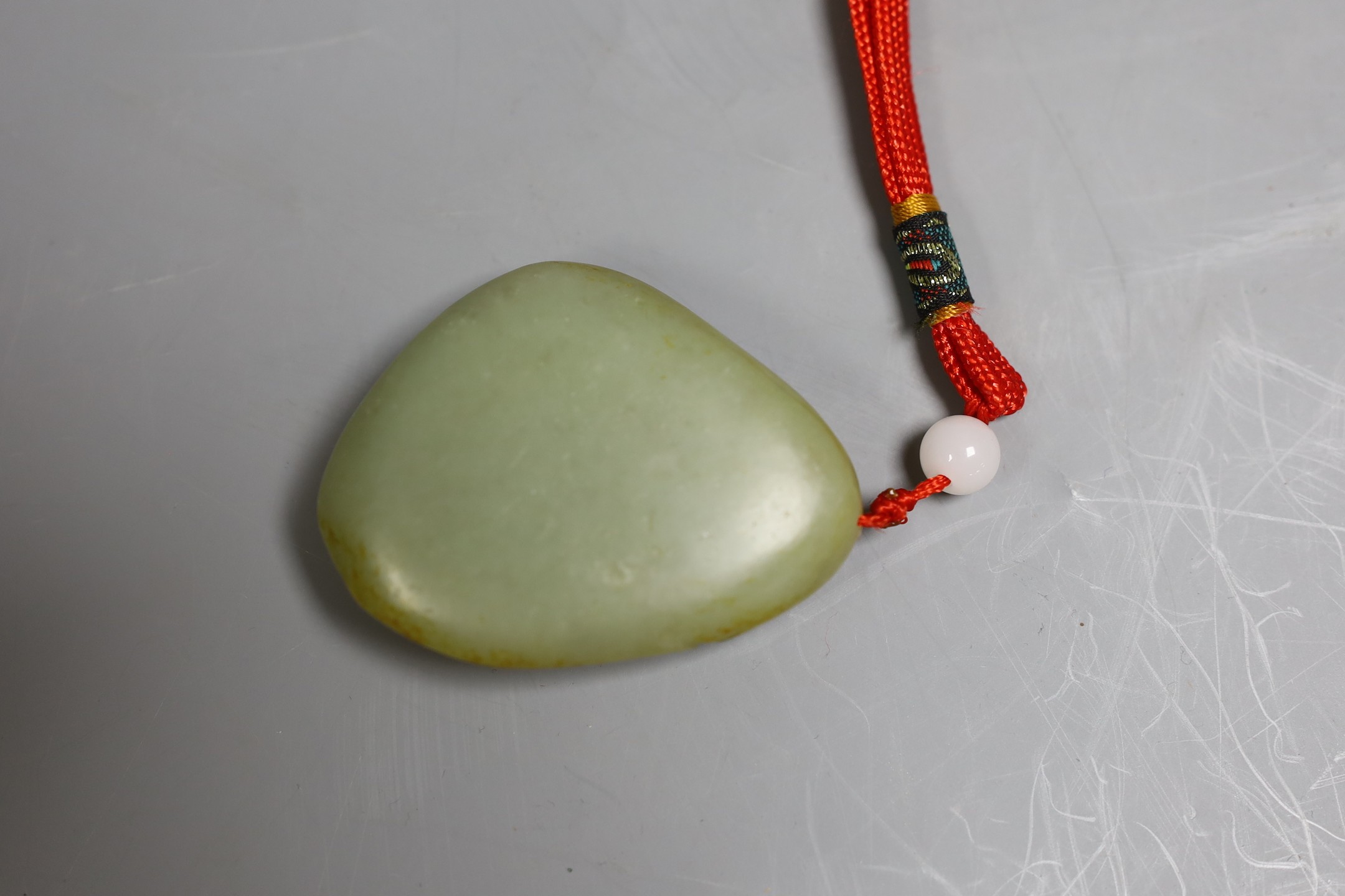 Chinese carved jade pendant of koi swimming among mid pondweed, 7cm tall